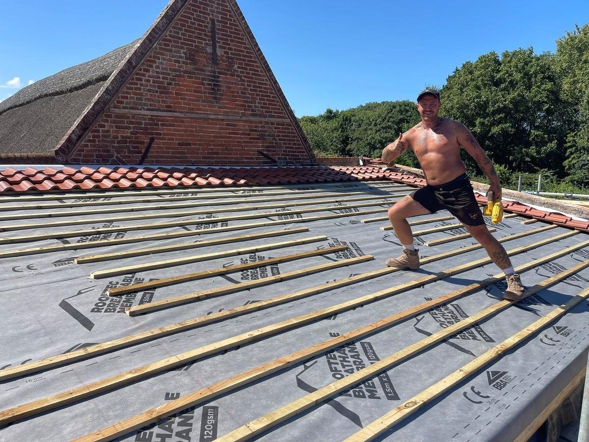 Rise Roofing team laying breathable membrane on a new roof